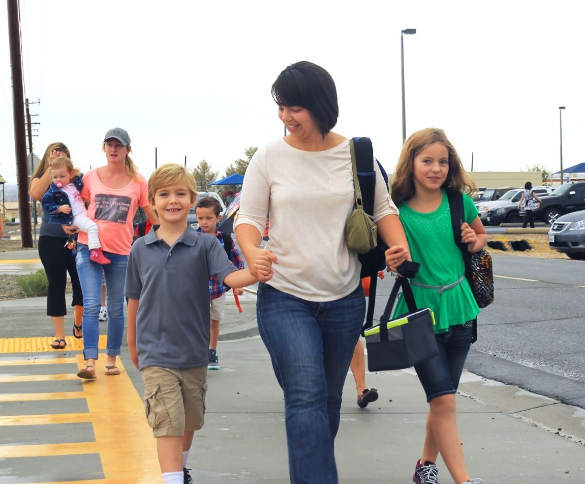 Adult with children holdinghands crossing the street