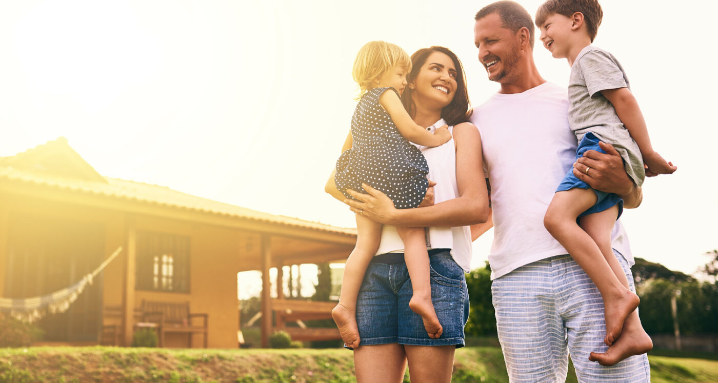 family poses in front of their home